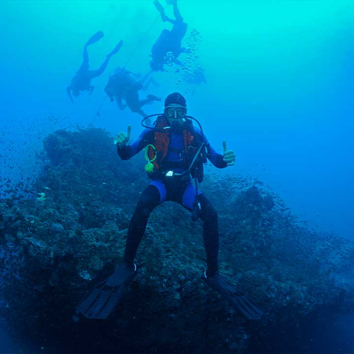 Scuba Diver giving thumbs up beside a coral reef in the Whitsunday Islands