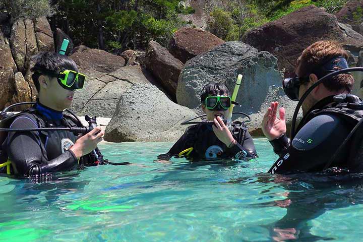 2 students in the water with their dive instructor at Blue Pearl Bay in the Whitsundays